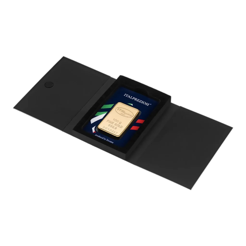 El Lingote de oro 100 gr se presenta en un estuche negro con cierre magnético, etiquetado "Italpreziosi" y decorado con rayas verdes, blancas y rojas que representan la bandera italiana.