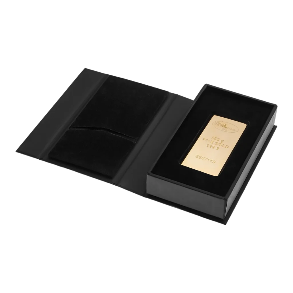 El Lingote de oro 500gr, con inscripciones, se presenta en un estuche negro abierto con un compartimento para el lingote de oro y un bolsillo vacío adyacente.