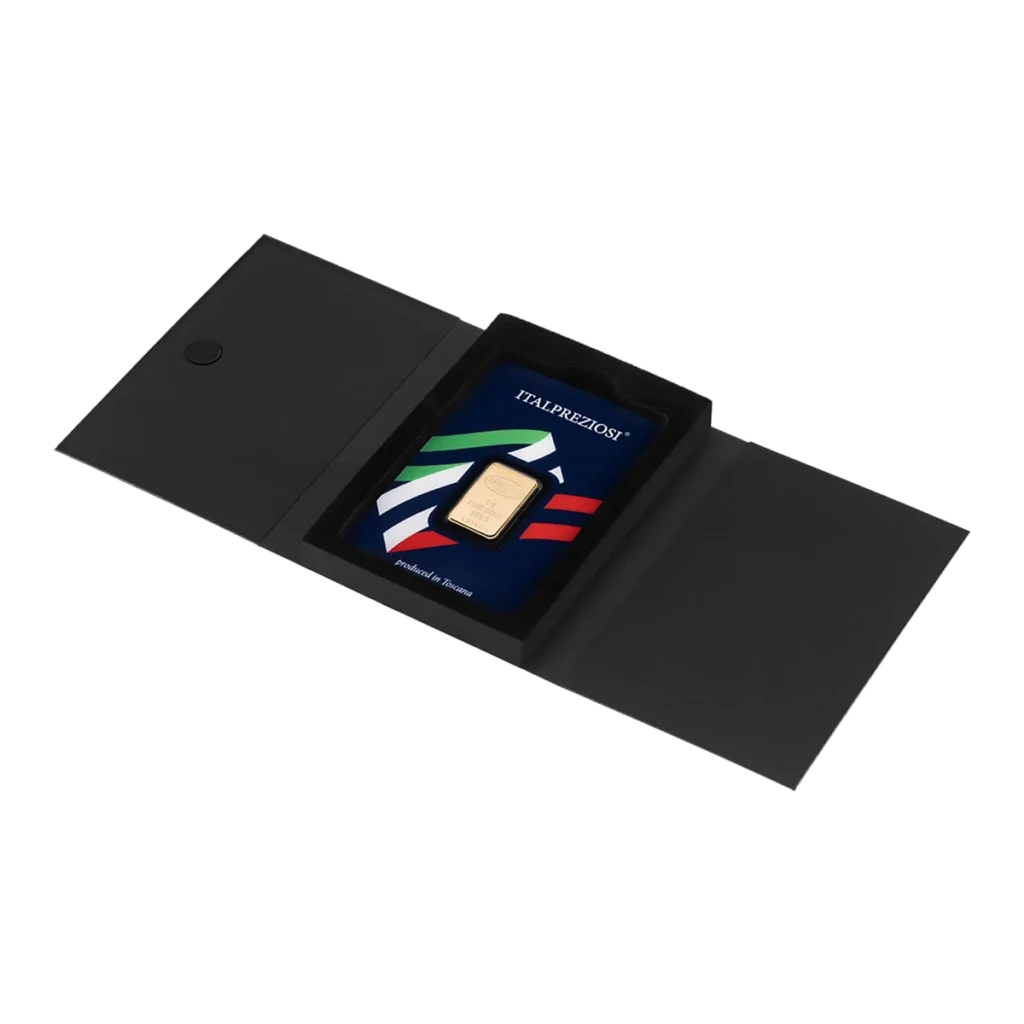 El Lingote de oro 5gr es un lingote de oro en un soporte azul con franjas rojas, blancas y verdes, presentado dentro de una carpeta negra abierta.