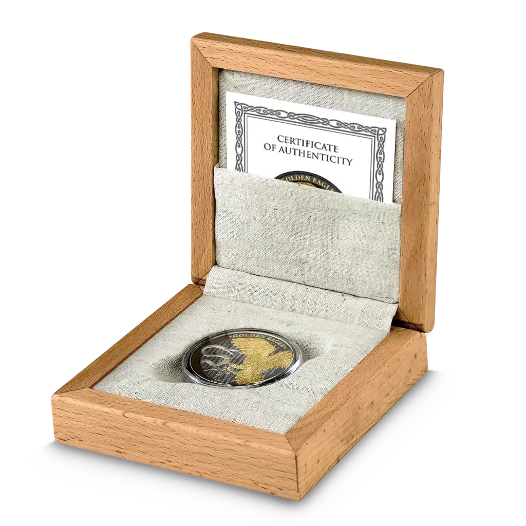 La moneda de colección Prime Bullion - 2024 Malta Golden Eagle 5 Euro 1 oz Plata BU Edición Limitada se presenta en un estuche transparente dentro de una caja de madera abierta forrada con tela ligera, acompañada de un certificado de autenticidad.