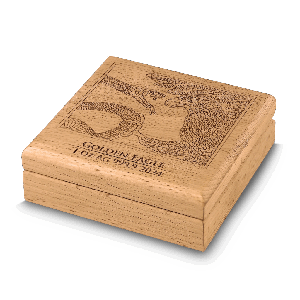 Un cofanetto in legno chiaro presenta un'incisione dettagliata di un'aquila e di un serpente sul coperchio, con la dicitura GOLDEN EAGLE 1 OZ AG 999.9 2024, per il Prime Bullion - 2024 Malta Golden Eagle 5 Euro 1 oz Argento BU Edizione Limitata.