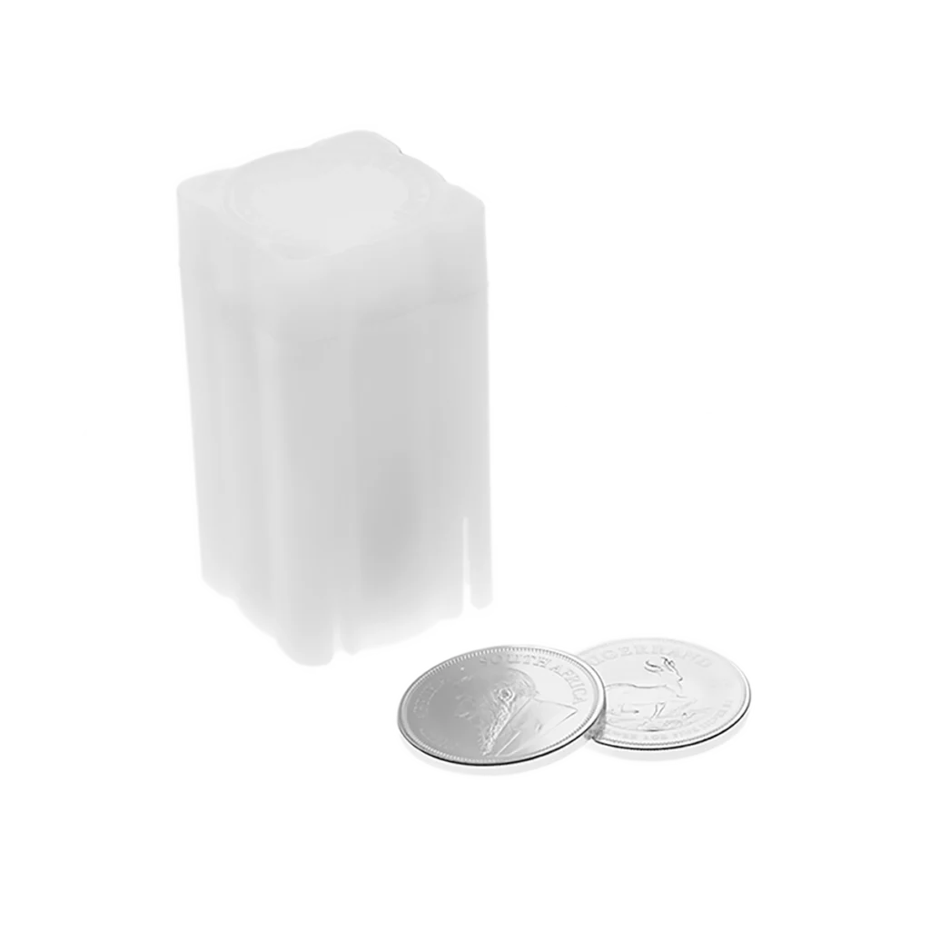 Un tubo de plástico blanco para monedas en posición vertical junto a dos monedas de Krugerrand de plata tumbadas sobre un fondo blanco. El tubo parece diseñado para guardar monedas de Krugerrand de plata.