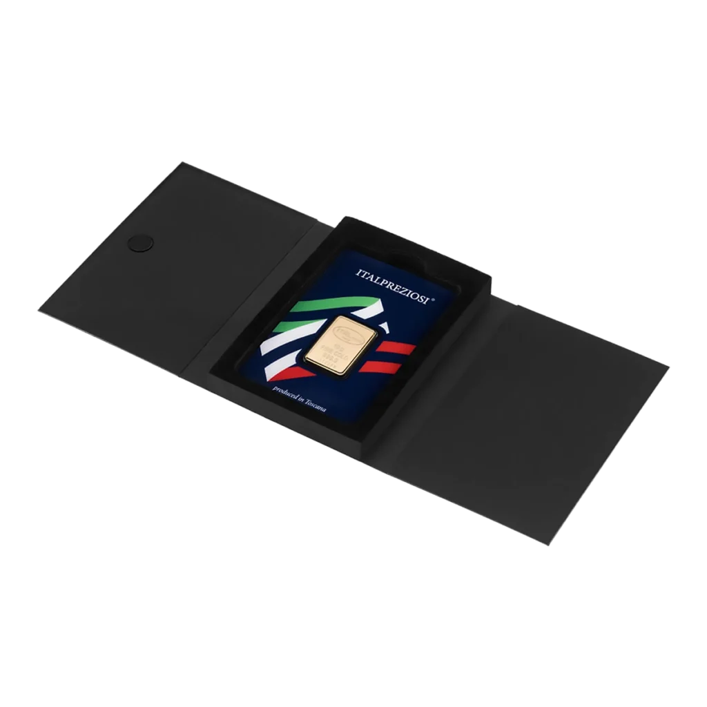 El Lingote de oro 10gr es un lingote rectangular de oro con un diseño azul, rojo, blanco y verde en un estuche expositor, presentado dentro de una caja negra abierta tipo carpeta.
