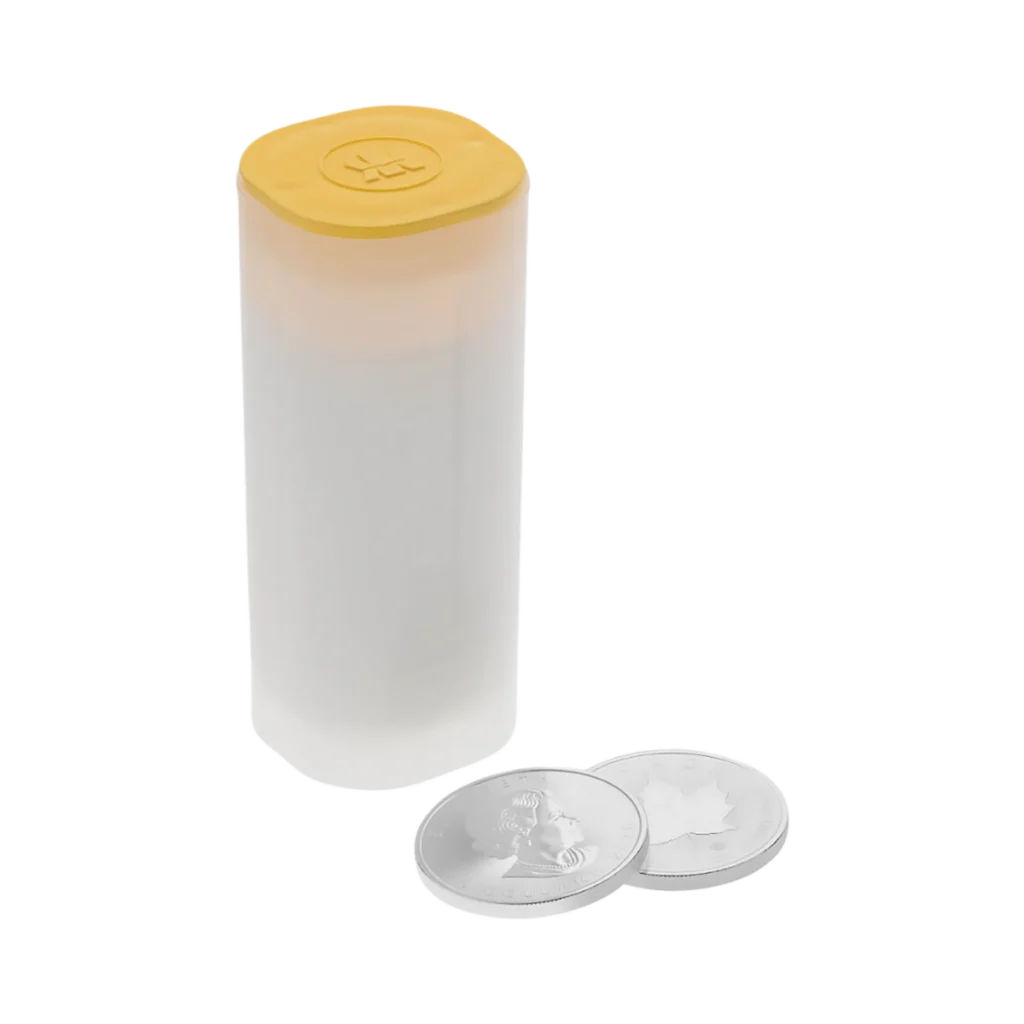 Un tubo de monedas de plástico blanco con tapa amarilla se encuentra en posición vertical junto a dos monedas Silver Maple Leaf -cada una plateada, con una hoja de arce y un retrato- sobre un fondo blanco liso.