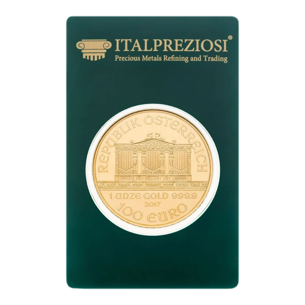 Una moneda de oro de la Filarmónica de Viena con la leyenda "REPUBLIK ÖSTERREICH 1 UNZE GOLD 999.9 2017 100 EURO" se presenta en un embalaje verde de Italpreziosi con letras doradas.