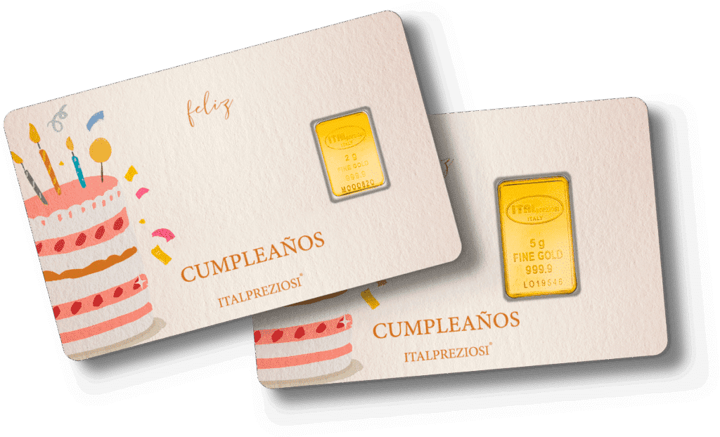 Dos tarjetas de felicitación "Cumpleaños", cada una con una ilustración de una tarta de cumpleaños y que contienen un pequeño lingote de oro en plástico, se muestran ligeramente superpuestas sobre un fondo blanco.