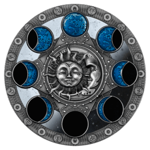 El Calendario Lunar 2 Dólares presenta una ilustración circular de fases lunares azules y negras alrededor de un sol y una luna centrales con caras, rodeados de símbolos zodiacales sobre un borde decorativo plateado.