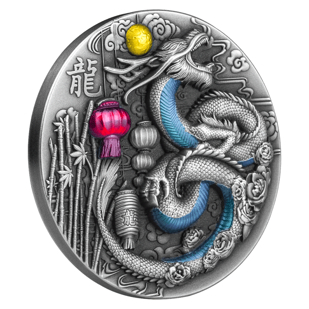 La moneda del Año del Dragón 2024 Francos CFA es redonda y de plata, y representa un intrincado dragón con detalles azules en medio de bambú, flores, un sol amarillo, una linterna roja y símbolos chinos grabados a la izquierda.