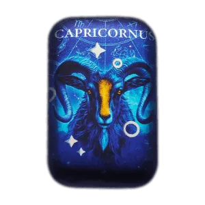 Lingotto d’argento 2 oz da collezione rettangolare con illustrazione del segno zodiacale Capricorno: testa frontale di capricorno blu con dettagli arancioni su sfondo blu stellato con scritta “CAPRICORNUS” in alto.