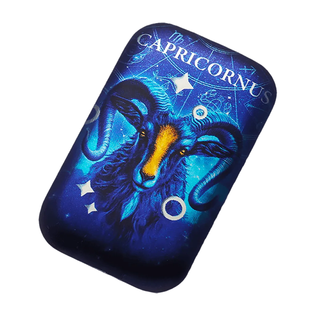 Vista inclinada del lingote de colección rectangular de plata de 2 oz con el signo del zodíaco Capricornio: cabeza de cabra de Capricornio azul de frente con detalles naranjas sobre un fondo azul estrellado, con “CAPRICORNUS” en la parte superior.