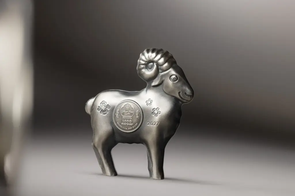 Moneta Fluffy Silver Sheep 2027 in argento in piedi su una superficie chiara, che mostra la forma tridimensionale autoportante e la finitura anticata.