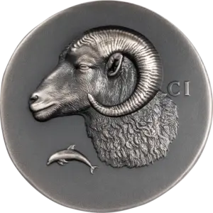 La moneta Numismatic Icons - Krios da 1 oz in argento 999.9 con finitura anticata mostra una testa di ariete in ultra alto rilievo, con corno a spirale e vello riccioluto, accanto a un delfino e alle lettere CI.