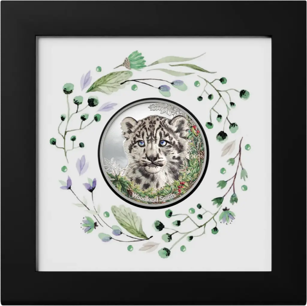 Moneta Woodland Spirits - Leopardo delle Nevi 1 oz argento nella cornice espositiva nera inclusa nella confezione, su sfondo bianco decorato da una ghirlanda di foglie e bacche ad acquerello.