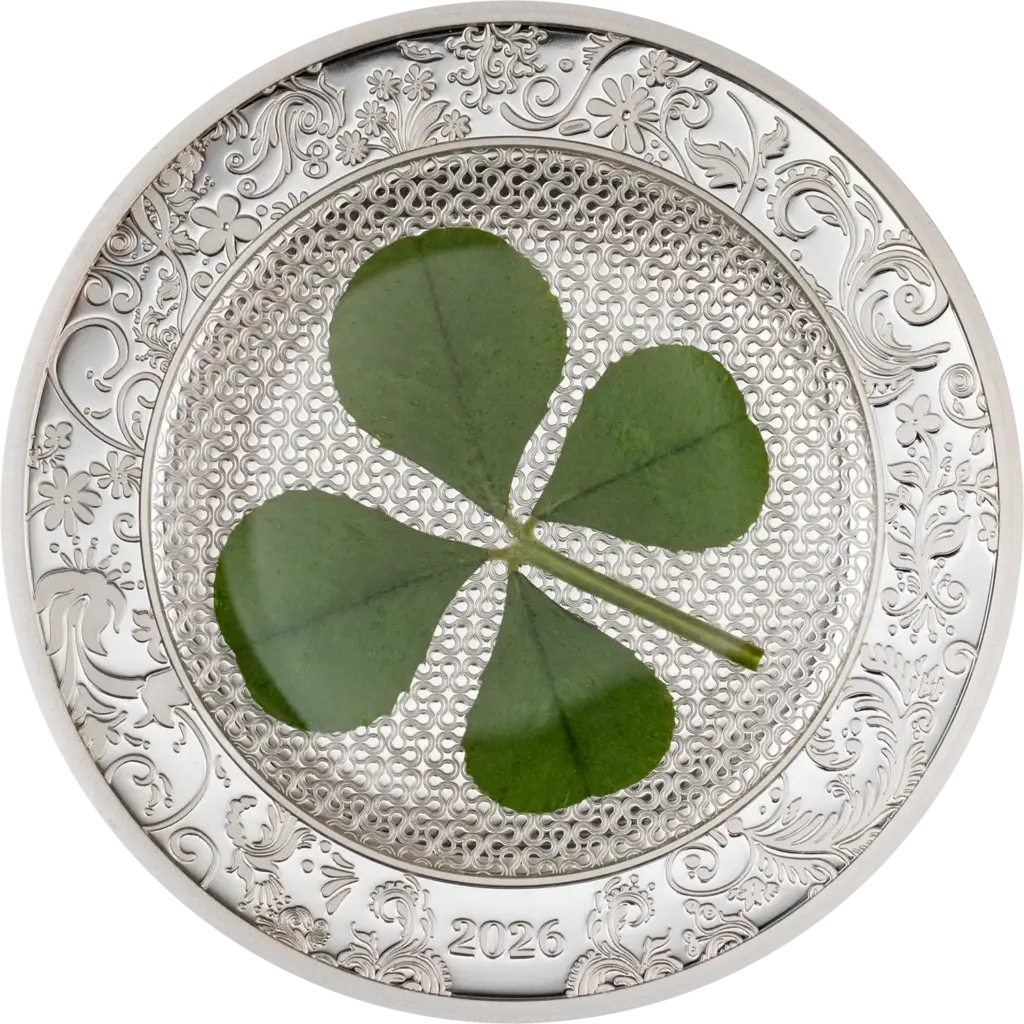La moneta Ounce of Luck 2026 da 1 oz in argento 999.9 proof racchiude un vero quadrifoglio verde su un fondo lavorato a rete, incorniciato da un bordo con decori floreali in rilievo e l'anno 2026.