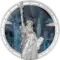 La moneta Timeless Icons - Statua della Liberta da 2 oz in argento 999.9 proof mostra la statua in altorilievo che sconfina oltre il bordo, su uno sfondo di smalto blu con lo skyline di Manhattan e il ponte di Brooklyn incisi a guilloche e la scritta E PLURIBUS UNUM lungo il bordo stellato.