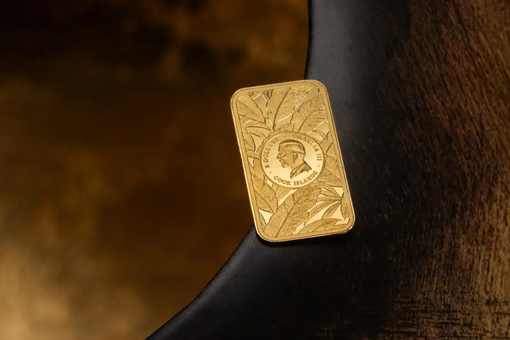 Moneta Barre de Luxe - Leopardo in oro fotografata dal lato dell'effigie di Carlo III su uno sfondo scuro con riflessi ambrati.