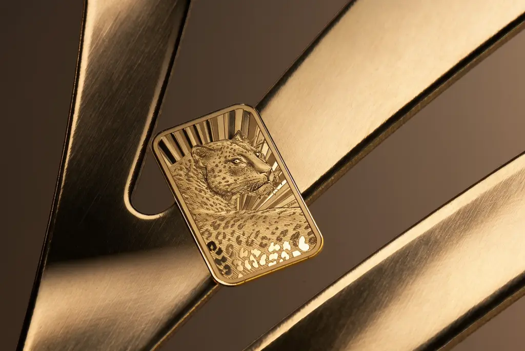 Moneta Barre de Luxe - Leopardo in oro appoggiata su nastri di metallo dorato, dal lato del leopardo.